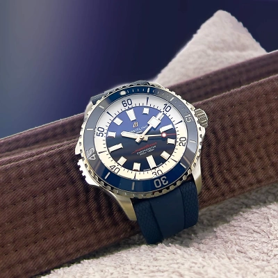 BREITLING Superocean - Uhr gestützt durch braunen Baumwollgurt, mit rosafarbenem Tuch und blauem Hintergrund