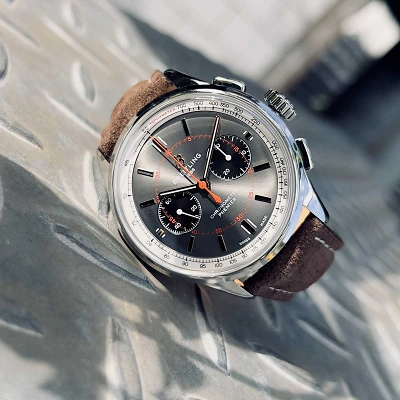 1 BREITLING Premier B01 - Uhr mit grauem Zifferblatt und Edelstahlgehäuse liegend auf einer Metalltreppe