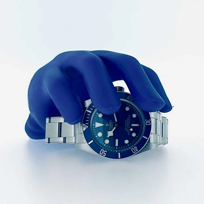 TUDOR Black Bay 58 - Uhr liegend, von vorne mit blauer Hand darüber