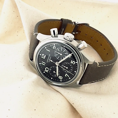 LONGINES Avigation BigEye - Uhr seitlich von vorne auf einem beigefarbenen Tuch.