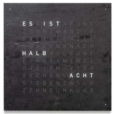 Die QLOCKTWO EARTH 13.5 in METAMORPHITE ist in der Front Ansicht. Ein stilvolles Kunstwerk wo jedes Exemplar ist ein Unikat, gefertigt auf echtem Stein.  Und das ikonische Buchstabenraster, das die Uhrzeit in Worten darstellt.