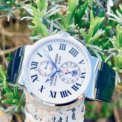 1 ULYSSE NARDIN Maxi Marine Chronometer - Uhr liegend von vorne mit grünen Pflanzen im Hintergrund